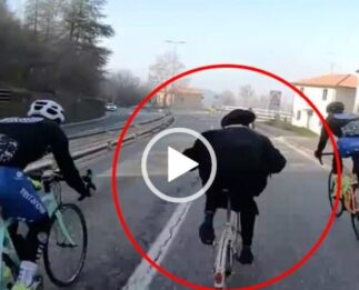 Un cura  en bici jugándose el tipo entre ciclistas y coches con la ayuda de Dios.